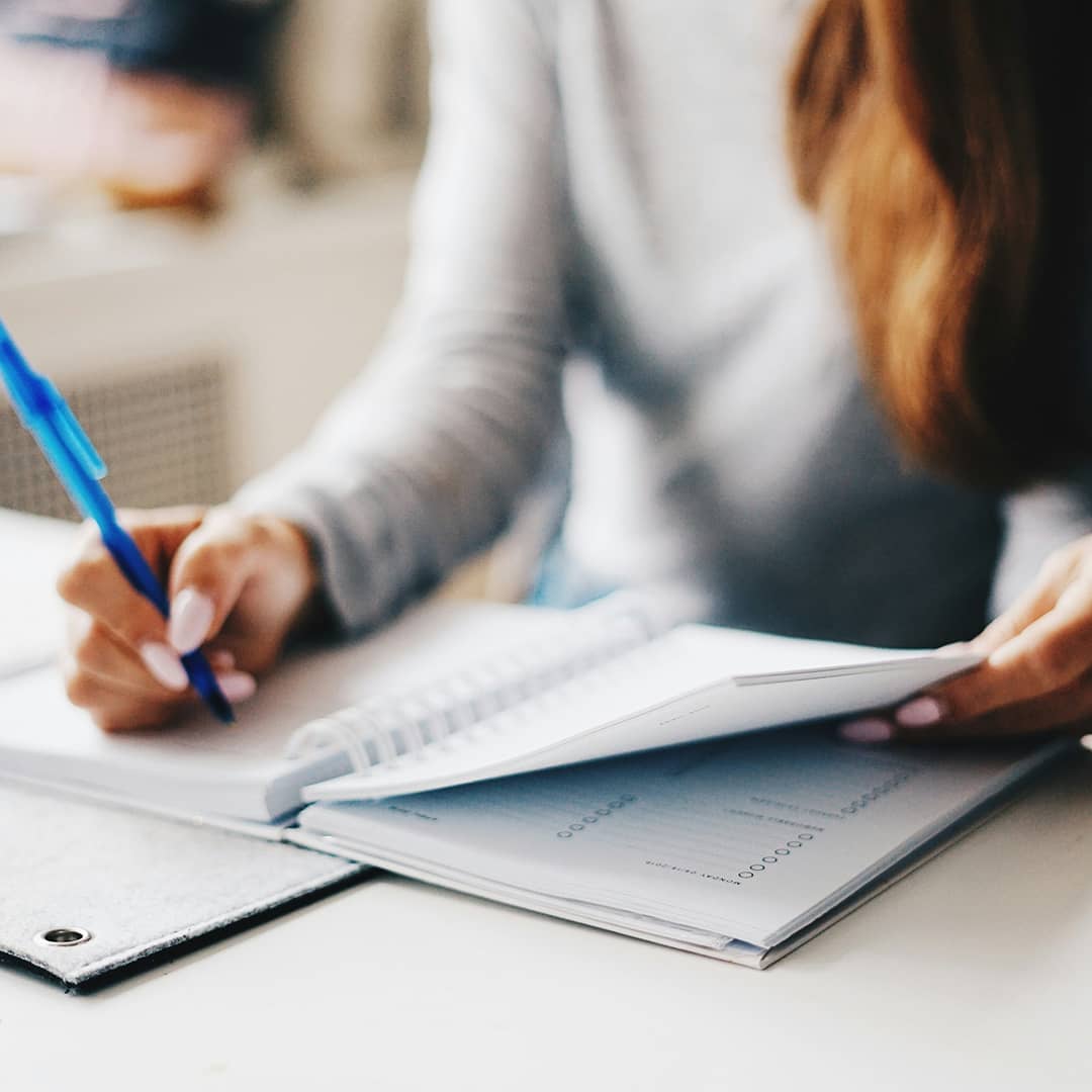 Une femme écrit dans un agenda